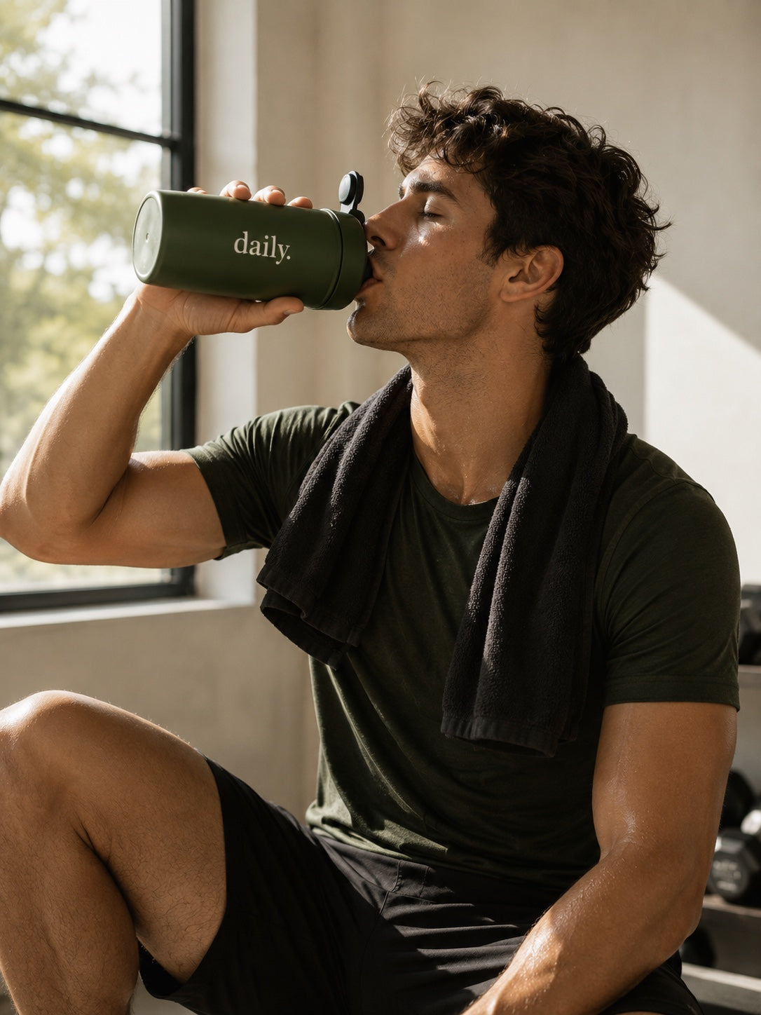 Man drinking from a daily. bottle after a workout